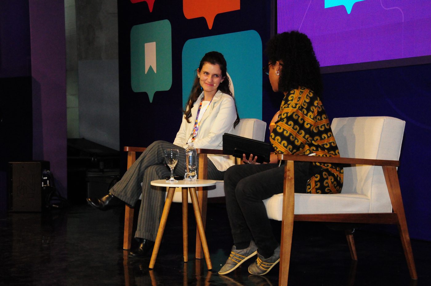 Juliana Mascarenhas conversando em um painel no palco